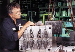 A worker carefully cleaning a custom molded piece.